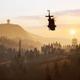 Silhouette di un elicottero in volo sopra una foresta di pini al tramonto nel videogioco Wardogs in accesso anticpato disponibile su Steam