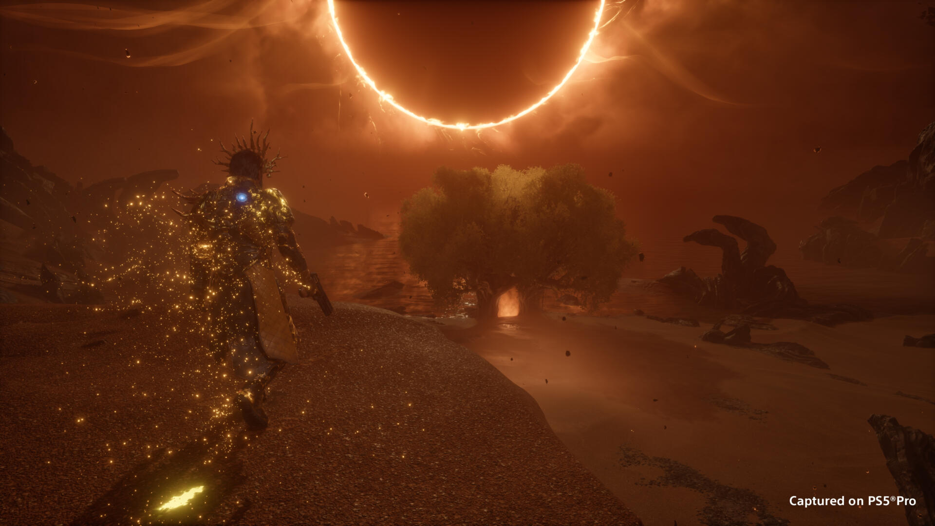 Saros Zenith: Arjun indossa la corazza dorata sotto l'eclissi su Carcosa, screenshot ufficiale su PS5 Pro