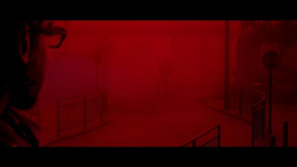 Il protagonista di Silent Hill: Townfall osserva una figura oscura immersa in una fitta nebbia rossa