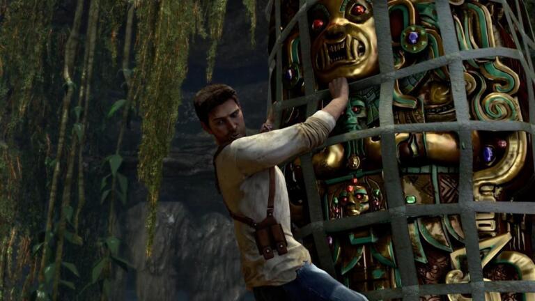 Uncharted The Nathan Drake Collection: Nathan Drake si aggrappa a una statua dorata in una rovina nella giungla, screenshot della versione PS4
