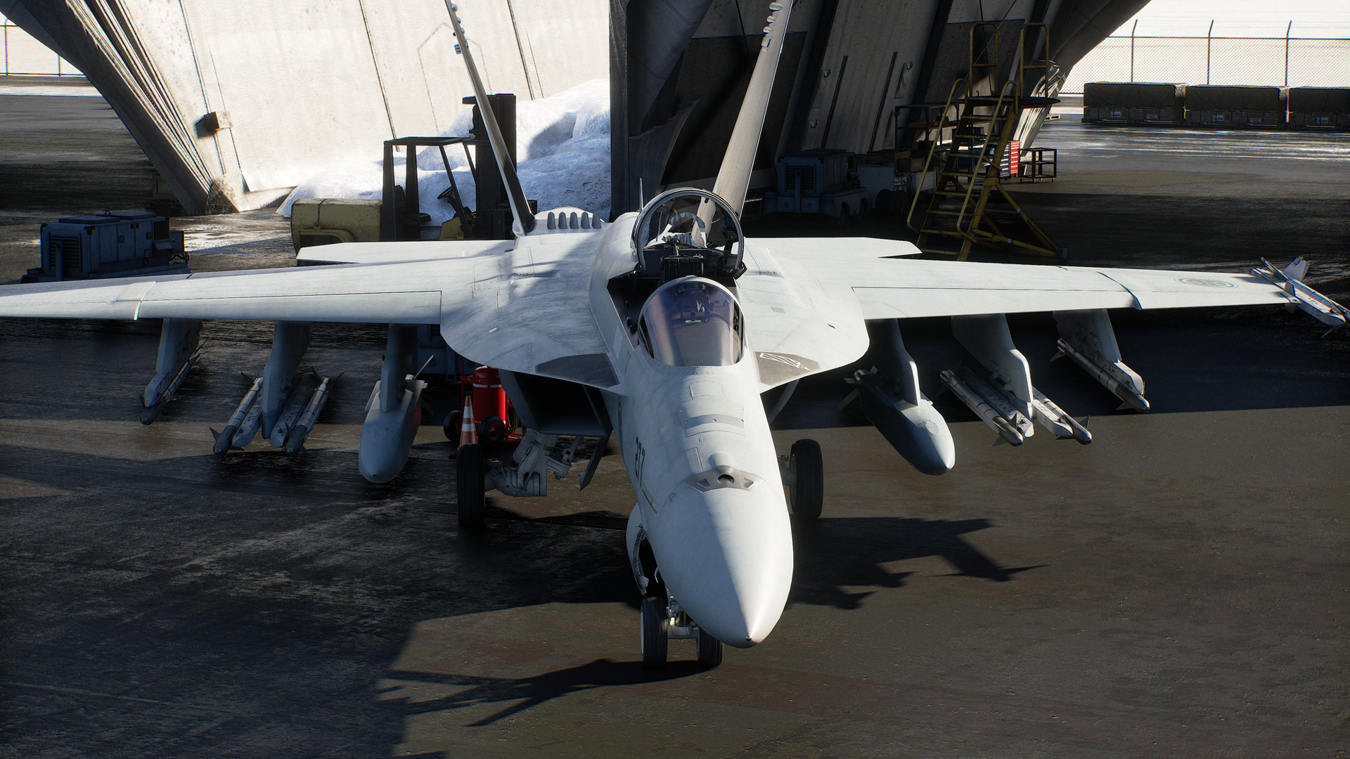 Screenshot in-game di Ace Combat 8: Wings of Theve che mostra un caccia da combattimento stazionato all'interno dell'hangar durante i controlli pre-volo.
